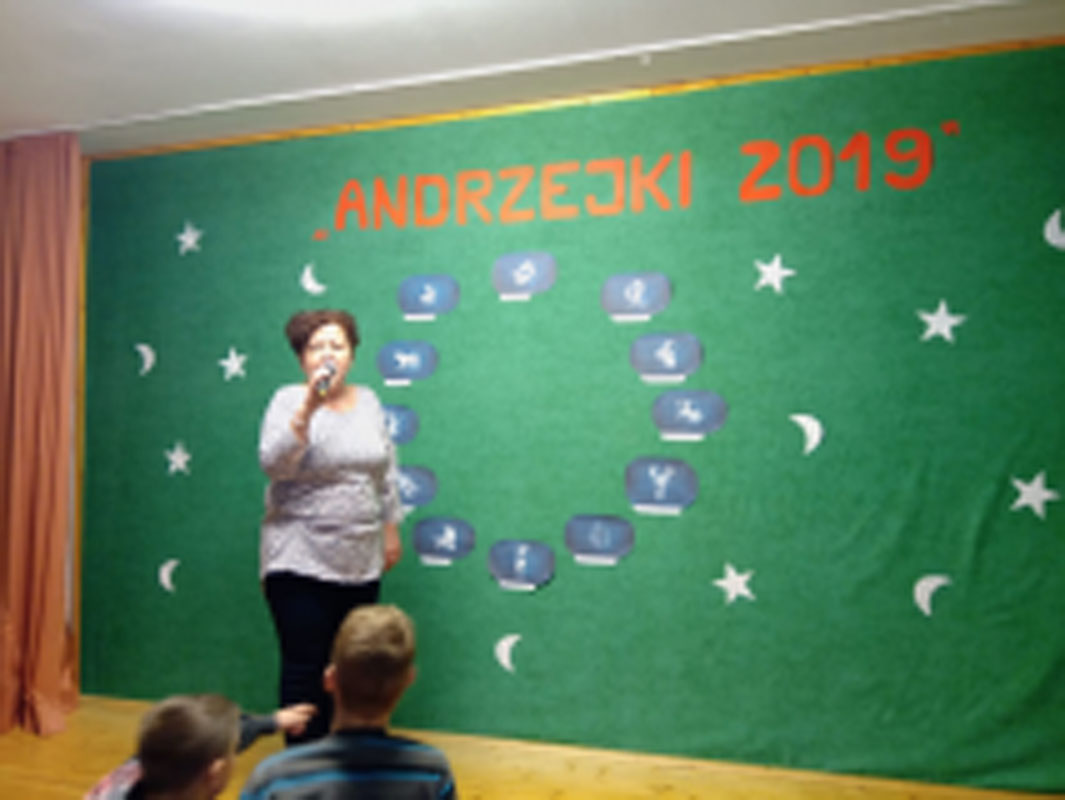 Uczniowie biorą udział w zabawach andrzejkowych, układają buty jeden za drugim, tańczą.