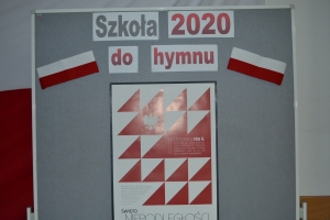 Na tle tablicy z biało-czerwonym sercem i napisem Serce dla Polski widoczna jest grupka dzieci w maseczkach. Jeden z chłopów ma uniesioną prawa rękę z palcami ułożonymi w znak zwycięstwa.ZSU Rabka