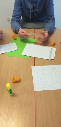 Uczniowie siedzą przy stolikach, rozwiązują rebusy, krzyżówki i wykreślanki, układają puzzle. Na stołach są ołówki, kleje, opakowania po jajkach niespodziankach, kartki w różnych kolorach. Uczniowie wykonują gazetkę z kart z zasadami bezpieczeństwa w siec