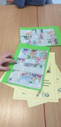 Uczniowie siedzą przy stolikach, rozwiązują rebusy, krzyżówki i wykreślanki, układają puzzle. Na stołach są ołówki, kleje, opakowania po jajkach niespodziankach, kartki w różnych kolorach. Uczniowie wykonują gazetkę z kart z zasadami bezpieczeństwa w siec