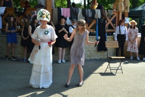 uczniowie przebrani w stroje z lat 20, 30,  tańczą, bawią się w stare gry, śpiewają, przedstawiają, oglądają teatrzyk