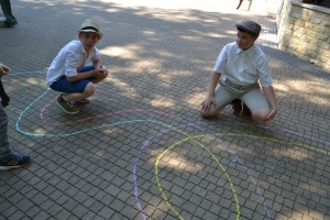 uczniowie przebrani w stroje z lat 20, 30,  tańczą, bawią się w stare gry, śpiewają, przedstawiają, oglądają teatrzyk