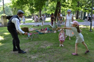 uczniowie przebrani w stroje z lat 20, 30,  tańczą, bawią się w stare gry, śpiewają, przedstawiają, oglądają teatrzyk