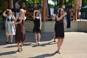 uczniowie przebrani w stroje z lat 20, 30,  tańczą, bawią się w stare gry, śpiewają, przedstawiają, oglądają teatrzyk