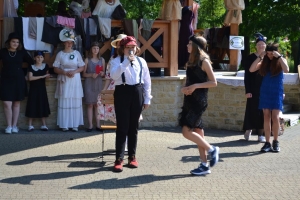 uczniowie przebrani w stroje z lat 20, 30,  tańczą, bawią się w stare gry, śpiewają, przedstawiają, oglądają teatrzyk