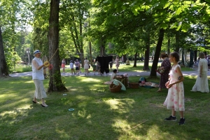 uczniowie przebrani w stroje z lat 20, 30,  tańczą, bawią się w stare gry, śpiewają, przedstawiają, oglądają teatrzyk