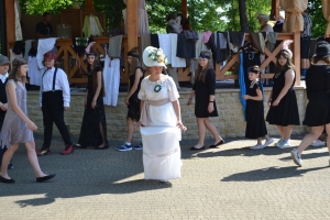 uczniowie przebrani w stroje z lat 20, 30,  tańczą, bawią się w stare gry, śpiewają, przedstawiają, oglądają teatrzyk