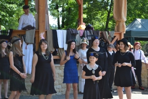 uczniowie przebrani w stroje z lat 20, 30,  tańczą, bawią się w stare gry, śpiewają, przedstawiają, oglądają teatrzyk