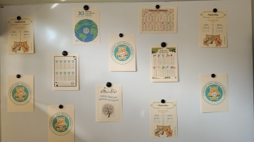 Uczniowie przy komputerach i stolikach. Układają wierze z plastikowych kubków, losują łyżeczki z zadaniami, grają w gry planszowe, rozwiązują zadania w programie komputerowym.