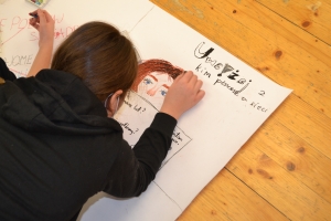 Uczniowie wykonują plakat na papierze wielkoformatowym.