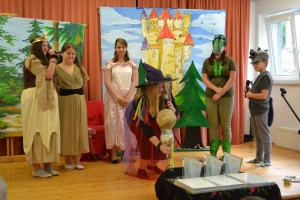 uczniowie na scenie tańczą, śpiewają, deklamują