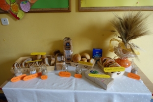 uczniowie ubrani w fartuszki jedzą chleb, oglądają film