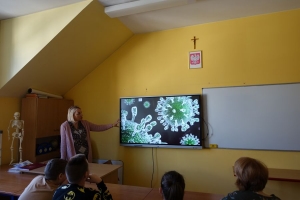 Uczniowie przy stolikach rysują, ogladają film.