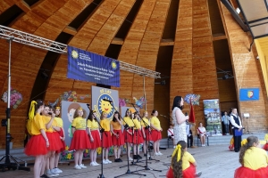 Występujący na scenie tańczą z pomponami, ze wstęgami. Na scenie dekoracja, pacynki Jacek i Agatka. Order Uśmiechu wręcza sekretarz Kapituły Orderu Uśmiechu i państwo Burcanowie.