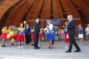 Występujący na scenie tańczą z pomponami, ze wstęgami. Na scenie dekoracja, pacynki Jacek i Agatka. Order Uśmiechu wręcza sekretarz Kapituły Orderu Uśmiechu i państwo Burcanowie.