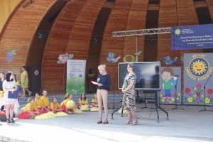 Występujący na scenie tańczą z pomponami, ze wstęgami. Na scenie dekoracja, pacynki Jacek i Agatka. Order Uśmiechu wręcza sekretarz Kapituły Orderu Uśmiechu i państwo Burcanowie.