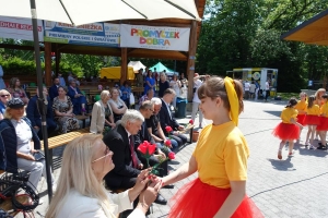 Występujący na scenie tańczą z pomponami, ze wstęgami. Na scenie dekoracja, pacynki Jacek i Agatka. Order Uśmiechu wręcza sekretarz Kapituły Orderu Uśmiechu i państwo Burcanowie.