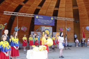 Występujący na scenie tańczą z pomponami, ze wstęgami. Na scenie dekoracja, pacynki Jacek i Agatka. Order Uśmiechu wręcza sekretarz Kapituły Orderu Uśmiechu i państwo Burcanowie.