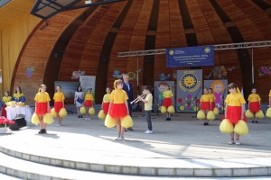 Występujący na scenie tańczą z pomponami, ze wstęgami. Na scenie dekoracja, pacynki Jacek i Agatka. Order Uśmiechu wręcza sekretarz Kapituły Orderu Uśmiechu i państwo Burcanowie.