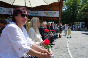 Występujący na scenie tańczą z pomponami, ze wstęgami. Na scenie dekoracja, pacynki Jacek i Agatka. Order Uśmiechu wręcza sekretarz Kapituły Orderu Uśmiechu i państwo Burcanowie.