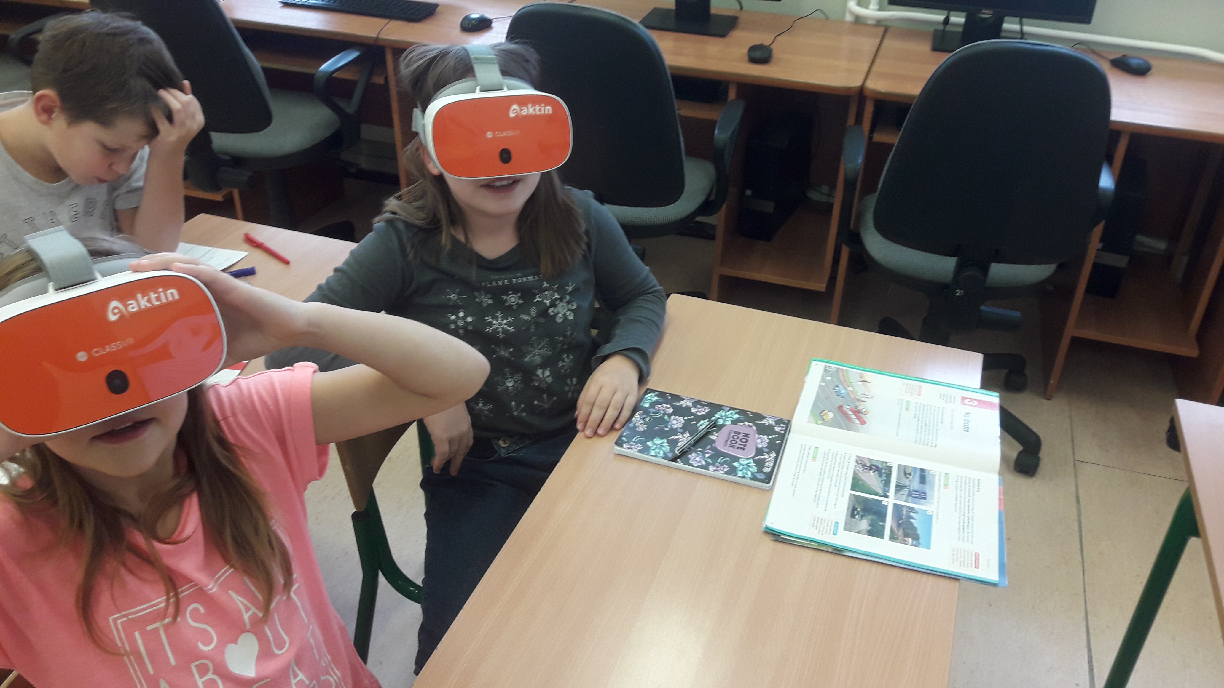 uczniowie siedzą w ławkach w okularach 