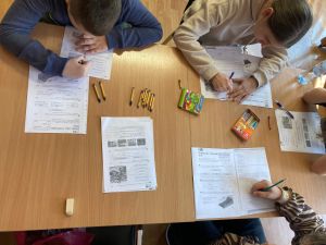 zdjęcie przedstawiające grupę uczniów wspólnie realizujących jakieś zadanie