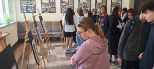 uczniowie przeglądający prace na korytarzu