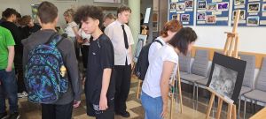 uczniowie przeglądający prace na korytarzu